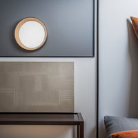 Minimalist dimple wall light illuminating a narrow indoor hallway